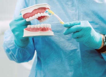 model-human-jaw-with-teeth-toothbrush-dentist-s-hand_217593-12370